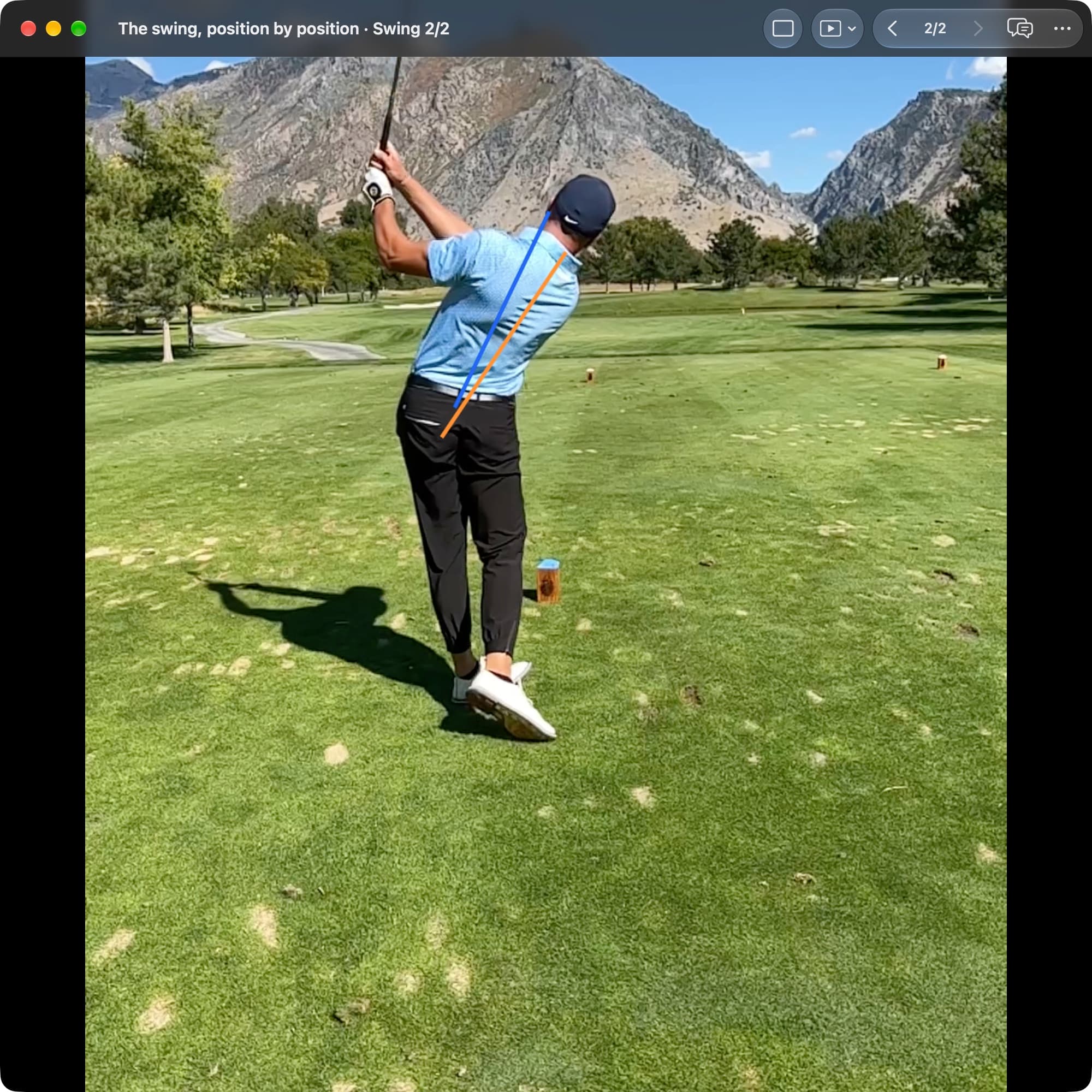 A golfer in MotionEdge Video Player, down-the-line on a course, at the finish with the hands high. An orange line shows the torso angle at Address and a blue line shows it now, much more upright.
