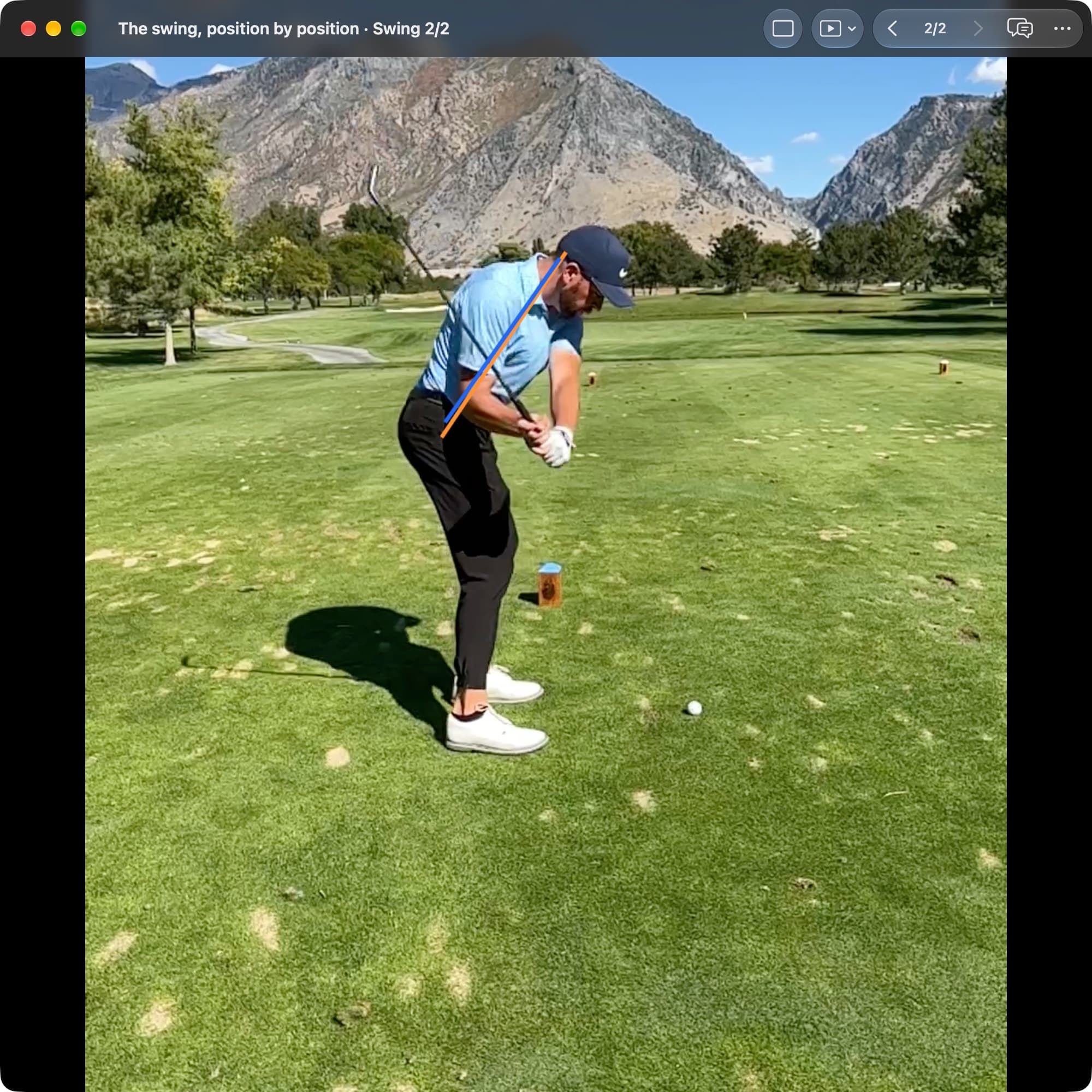 A golfer in MotionEdge Video Player, down-the-line on a course, just before impact. An orange line shows the torso angle at Address and a blue line shows it now, close to the same angle.